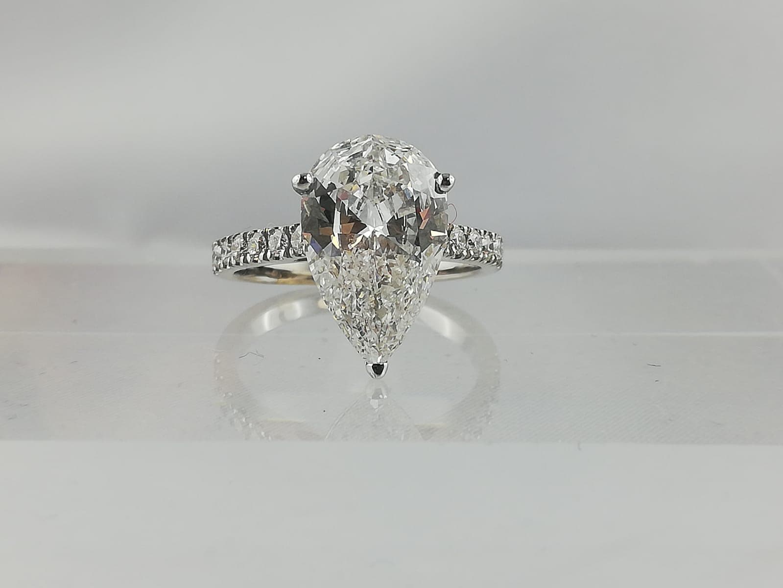 GIA gemological grading report alongside a pear cut diamond ring